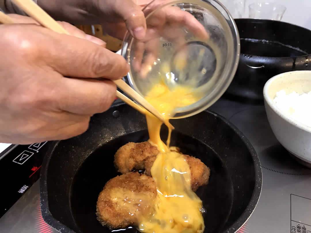 カツをつゆに入れて軽く煮たら、溶き卵の半分(1個分)を回しかけます。