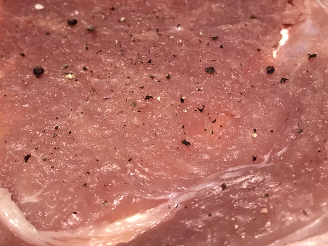 お肉が十分薄くなったら塩コショウし、まな板から優しくはずします。