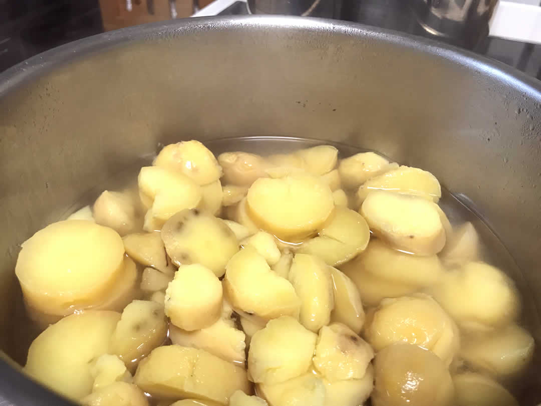 材料がひたひたになるくらいの水に固形ブイヨンを入れて煮立たせ、食べやすい大きさに粗く切ったジャガイモを投入して数分煮ます。