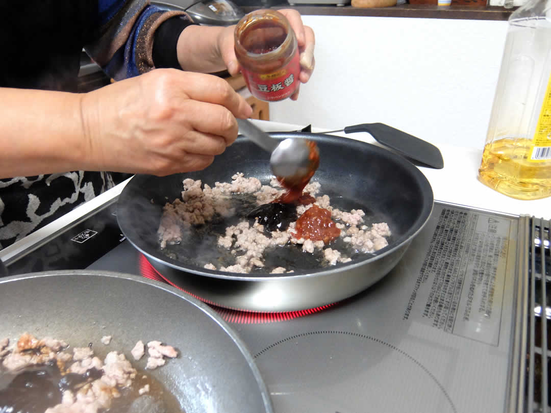 お肉の脂が溶け出てきたところで、まず甜面醤・豆板醤を投入。