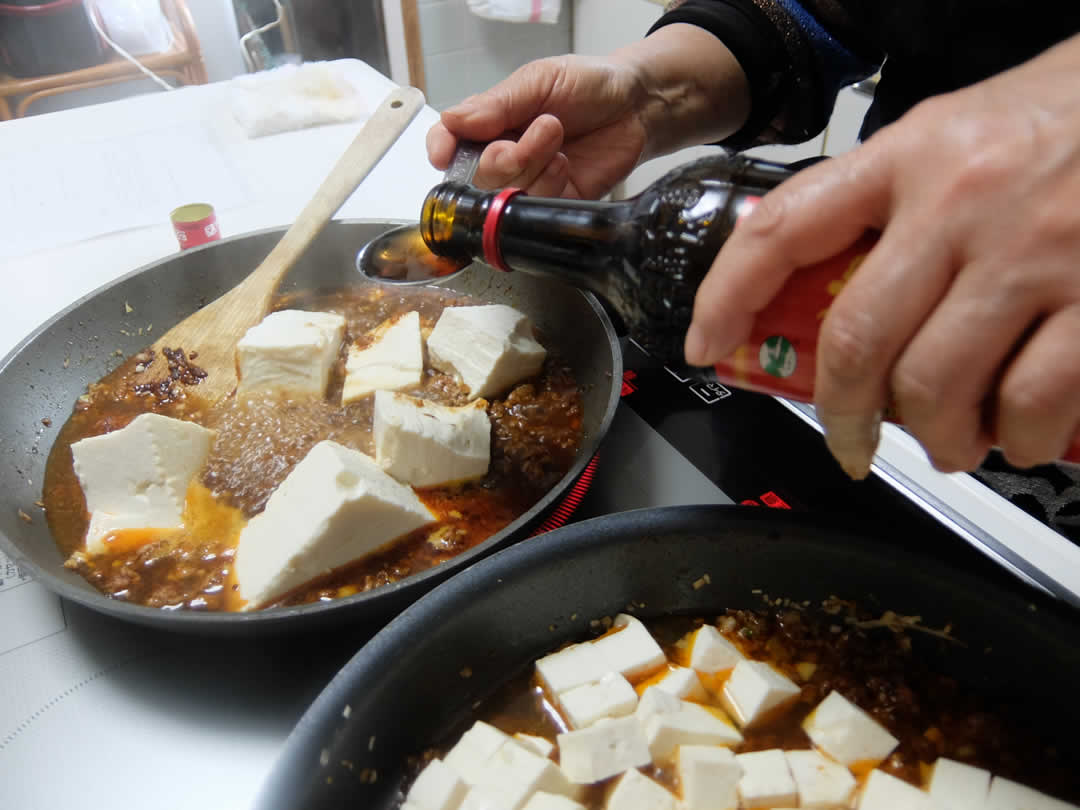 お豆腐を煮込んだら鶏ガラスープを投入。つづいてお酒大匙1を投入。紹興酒か老酒を使います。つづいて醤油大匙1.5・砂糖小さじ2・コショウ少々を加えます。