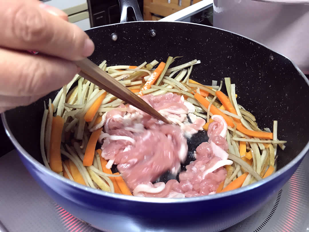 ごぼうに完全に火が通ったら、フライパンの真ん中を空けて、ここで初めて豚肉を投入します。