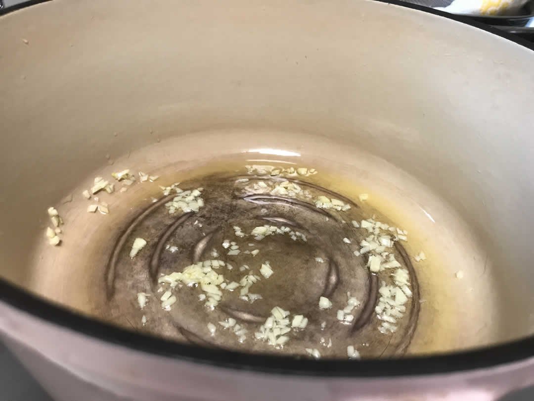 さっそくチリコンカーンの調理にかかります。厚手の鍋を熱して、オリーブオイルでみじん切りのにんにくを炒めます。