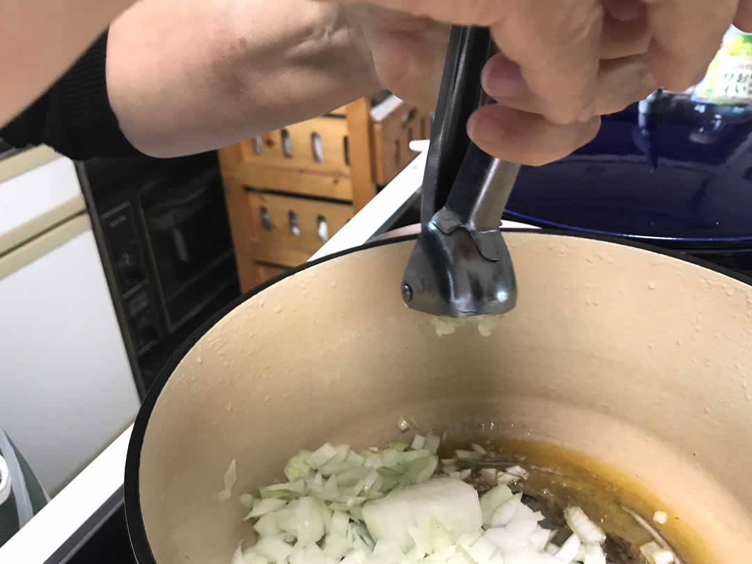 炒めた油で玉ねぎを炒め、にんにくは1片ずつ絞り器でつぶしながら3片程度入れます