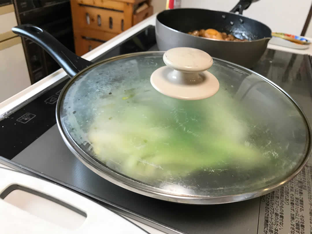 フライパンに熱湯を多めに入れたら、蓋をして数分間蒸し焼きにして火を通します。