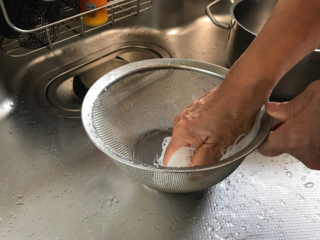 戻したビーフンをざるに取り、いったん水で冷やします。ここでぎゅっと手で押さえて水気をよく切っておくのも重要なポイント。
