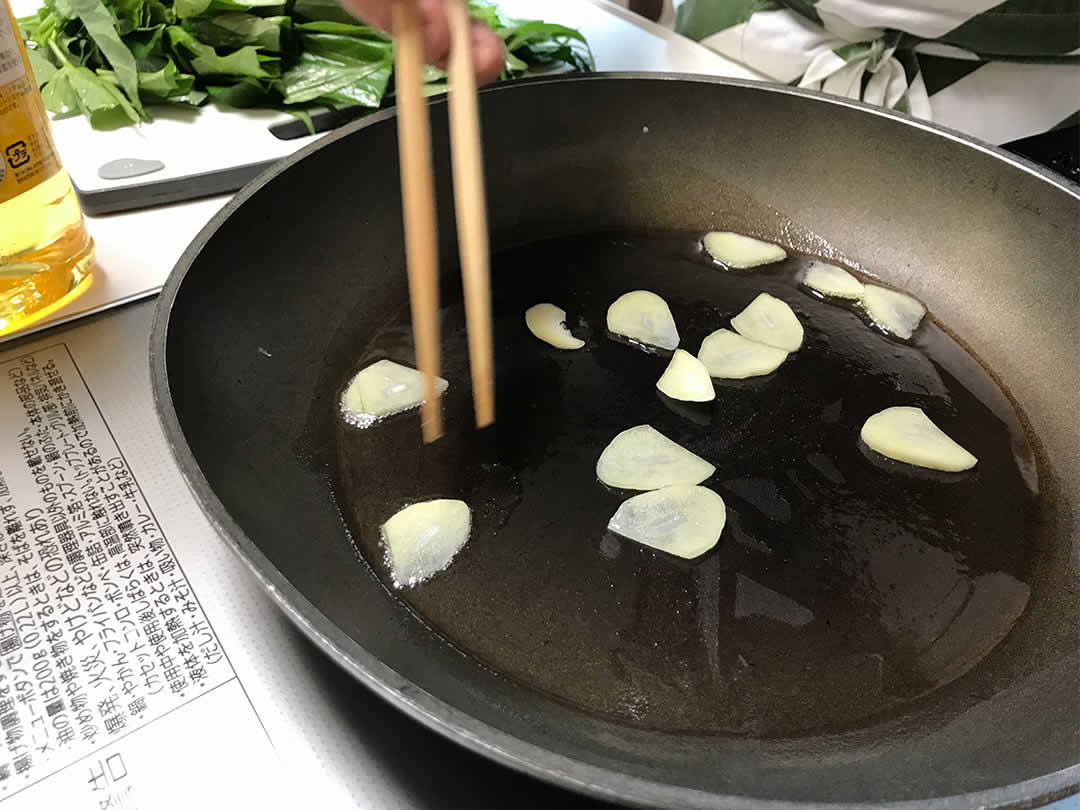 ニンニクひとかけを薄いスライスにし、油で炒めます。