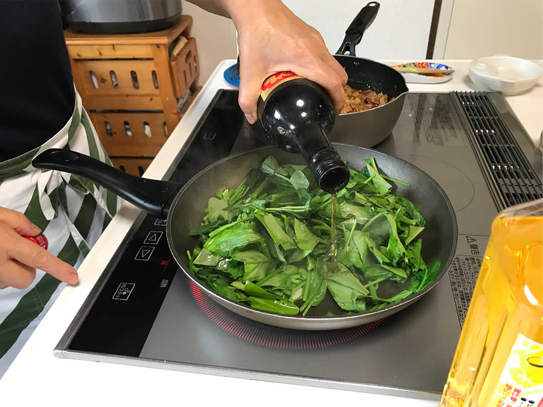 空心菜は食べやすい大きさに切り分け、根の部分から先に炒めはじめます。追って葉の部分を投入。紹興酒を少量ふりかけ、塩を加えて全体をよく炒めます。