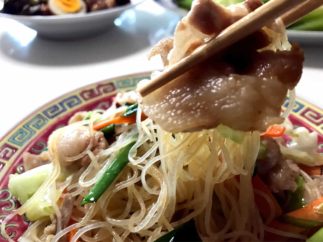 中華風のお皿に盛り付けられた焼きビーフンは、絶妙な炒め加減！お肉もお野菜もつやつや輝いています。