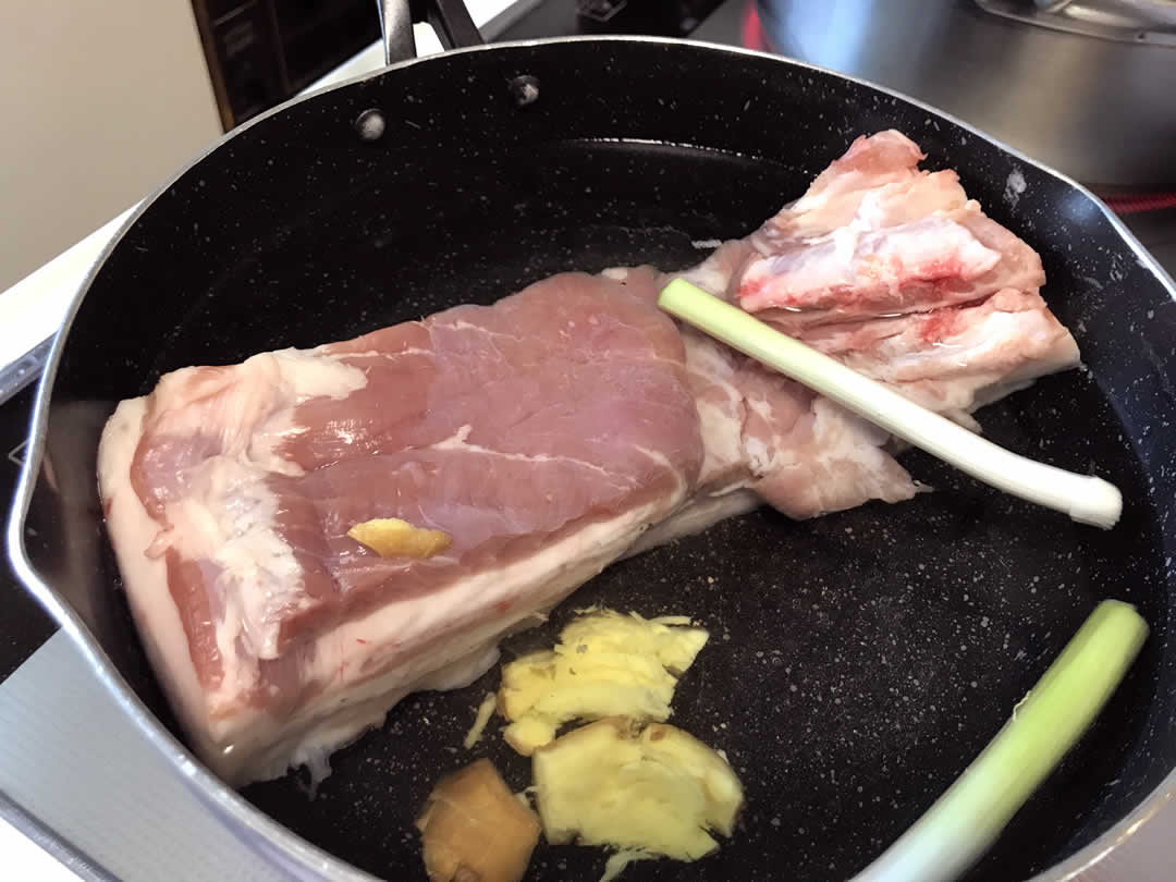 鍋にたっぷりの水を入れ、香味野菜の九条ネギとしょうがを投入します。
